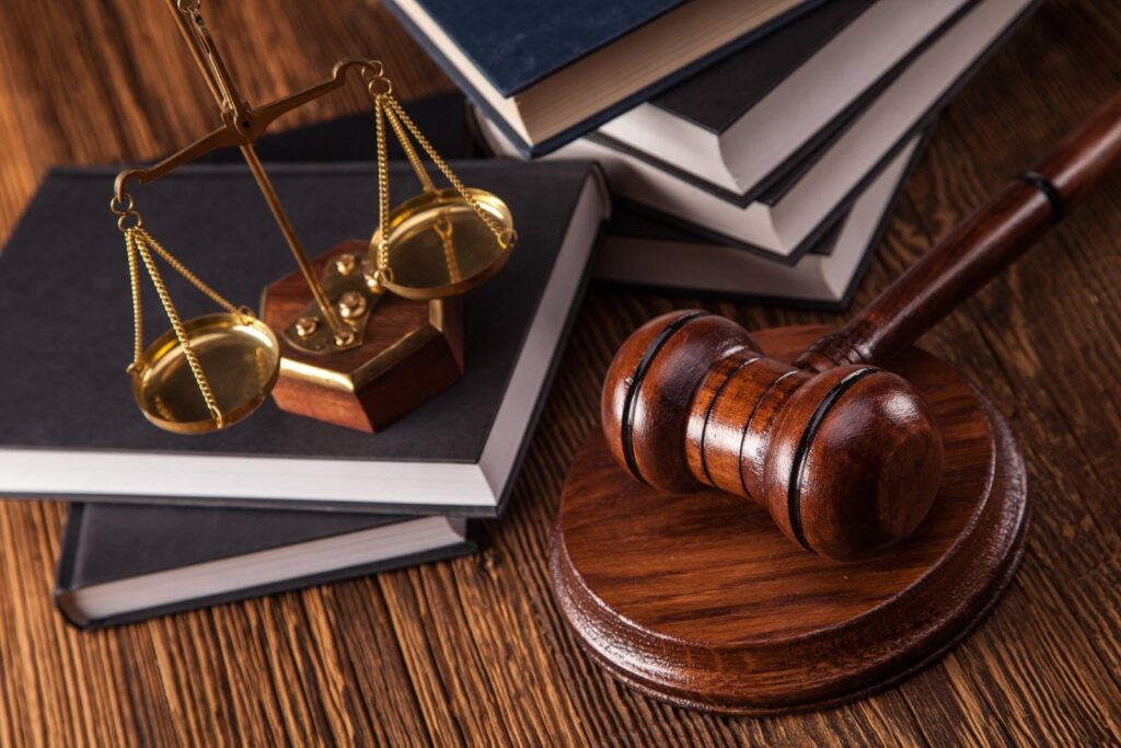Legal hammer gavel and golden scales of justice on law reference books representing professional court advocacy by Pakistan Legal Attorneys.